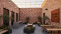 The Gumtree Courtyard outdoor brick patio featuring overhead string lights, wooden tables, and concrete bar counter.