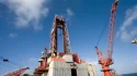 Offshore drilling rig platform with heavy-duty lattice boom crane under clear sky